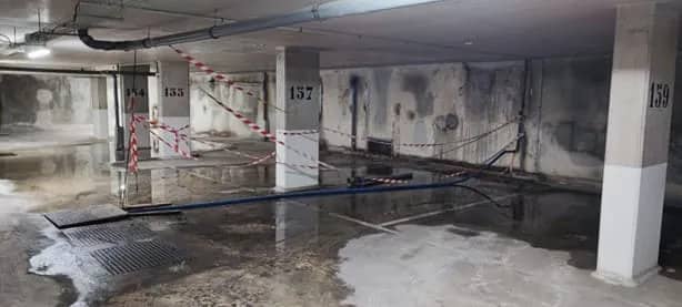 Parking souterrain inondé, zone balisée après un sinistre